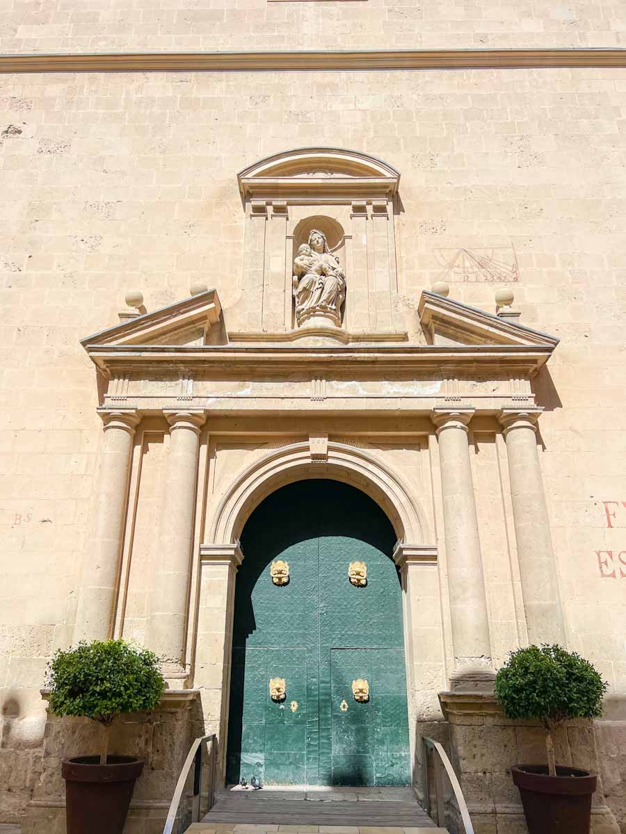 the front facade and green door with gold knockers of the church Santa Iglesia Concatedral de San Nicolás de Bari de in Alicante